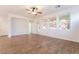 Bright living room with wood-look tile flooring, ceiling fan, and large windows for natural light at 925 Crescent Falls St, Henderson, NV 89011