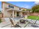 Outdoor space with artificial turf, fire pit and a covered pergola seating area at 9630 Tuscola Ct, Las Vegas, NV 89148