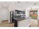 Modern kitchen featuring granite counters, stainless steel appliances, black cabinetry, and backyard access at 9630 Tuscola Ct, Las Vegas, NV 89148