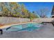 Backyard with a sparkling pool, mature trees, and a block wall at 976 El Camino Way, Boulder City, NV 89005