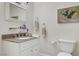 Well-maintained bathroom with a granite vanity top, white cabinetry, and a decorative painting at 976 El Camino Way, Boulder City, NV 89005