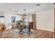 A stylish dining area showcases a glass table, modern chandelier, and seamless flow into the kitchen at 976 El Camino Way, Boulder City, NV 89005
