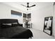 Bedroom with a black bed set, two windows with black roller shades, and a ceiling fan at 9815 Evergreen Pine St, Las Vegas, NV 89166