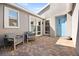 Inviting outdoor courtyard featuring a brick patio, comfortable seating, and a vibrant blue entry door at 9815 Evergreen Pine St, Las Vegas, NV 89166