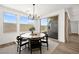 Bright dining area with backyard views, modern lighting and comfortable seating with a neutral rug at 9815 Evergreen Pine St, Las Vegas, NV 89166