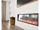 Modern fireplace creates a warm ambiance next to the sectional, complete with hardwood flooring and accent decor at 9815 Evergreen Pine St, Las Vegas, NV 89166