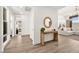 Warm foyer featuring light wood floors, a modern table, and a view into the spacious living area at 9815 Evergreen Pine St, Las Vegas, NV 89166