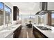Modern kitchen with dark wood cabinets, white countertops, and a dining area bathed in natural light at 9815 Evergreen Pine St, Las Vegas, NV 89166