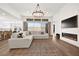 Bright, open living area features a cozy fireplace, a large sectional, and ample natural light at 9815 Evergreen Pine St, Las Vegas, NV 89166