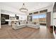 Bright, open living area with a large sectional sofa, hardwood floors, and expansive windows offering great light at 9815 Evergreen Pine St, Las Vegas, NV 89166