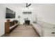 Bright living room with modern decor, light wood floors, white leather sofa, and stylish shelving unit at 9815 Evergreen Pine St, Las Vegas, NV 89166