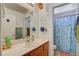 Bright bathroom featuring a spacious vanity, large mirror, and a charming mermaid-themed shower curtain at 1007 Shades End Ave, North Las Vegas, NV 89081