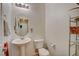 Cozy half bathroom featuring a pedestal sink, toilet, and a decorative mirror at 1007 Shades End Ave, North Las Vegas, NV 89081