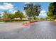View of paved entrance into the Cottages at Centennial Ranch with well-manicured landscaping and mature trees at 1007 Shades End Ave, North Las Vegas, NV 89081