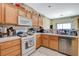 Efficient kitchen with wood cabinets, white appliances, and tile countertops at 1007 Shades End Ave, North Las Vegas, NV 89081