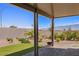 Large covered patio with brick pavers, synthetic grass, and lush desert landscaping at 1047 Atkins Ln, Mesquite, NV 89027