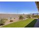 Desert landscaped backyard with artificial turf, a covered patio, and mountain views at 1047 Atkins Ln, Mesquite, NV 89027