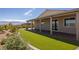 The backyard features manicured artificial turf, a covered patio, and low-maintenance landscaping at 1047 Atkins Ln, Mesquite, NV 89027
