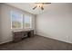 Bedroom with neutral carpet, ceiling fan, and desk beneath two windows at 1047 Atkins Ln, Mesquite, NV 89027