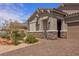 Inviting home exterior featuring desert landscaping, stone accents, and a well-manicured lawn at 1047 Atkins Ln, Mesquite, NV 89027