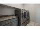 Close-up of laundry room featuring gray cabinetry, granite countertop and a stainless steel washer and dryer at 1047 Atkins Ln, Mesquite, NV 89027