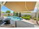 Relaxing backyard with a covered patio, in-ground pool, fire pit, manicured garden, and privacy wall at 10579 Garden Rose Dr, Las Vegas, NV 89135