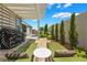 Inviting backyard with pergola-covered patio, lounge chairs, lush landscaping, and a barbecue area for outdoor enjoyment at 10579 Garden Rose Dr, Las Vegas, NV 89135