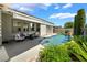Well-kept backyard showcases an in-ground pool, patio with seating, verdant shrubs, and attractive landscaping at 10579 Garden Rose Dr, Las Vegas, NV 89135