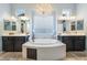 This large bathroom includes a central jetted tub and and vanities with excellent lighting at 10579 Garden Rose Dr, Las Vegas, NV 89135