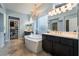 A luxurious bathroom with a chandelier over a soaking tub and and sink vanities at 10579 Garden Rose Dr, Las Vegas, NV 89135