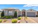 Charming single-story home featuring a stone facade, manicured landscaping, and a two-car garage at 10579 Garden Rose Dr, Las Vegas, NV 89135