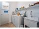 Functional laundry room with washer, dryer, utility sink, shelving, and a window for natural light at 10579 Garden Rose Dr, Las Vegas, NV 89135