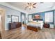 Spacious main bedroom featuring wood floors, plantation shutters, ceiling fan and decorative touches at 10579 Garden Rose Dr, Las Vegas, NV 89135