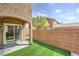 Backyard featuring artificial grass, a brick fence, and a sliding glass door with an archway at 10636 Colter Bay Ct, Las Vegas, NV 89129