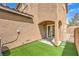Backyard featuring artificial grass, a sliding glass door, and an archway on a sunny day at 10636 Colter Bay Ct, Las Vegas, NV 89129