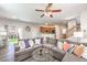 Comfortable living room with gray sectional, ceiling fan, and sliding glass doors to the backyard at 10636 Colter Bay Ct, Las Vegas, NV 89129