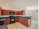 Traditional kitchen with wooden cabinets, black countertops, and updated appliances at 1115 Aldenwood Ave, Las Vegas, NV 89123