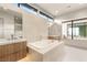 A modern bathroom featuring a soaking tub, double sinks and a view to the main bedroom at 11152 San Terrazo Pl, Las Vegas, NV 89141