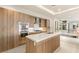 Contemporary kitchen with stainless steel appliances, custom cabinets, and an island with a white countertop at 11152 San Terrazo Pl, Las Vegas, NV 89141