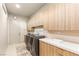 Modern laundry room featuring front loading washer and dryer, and ample cabinet space at 11152 San Terrazo Pl, Las Vegas, NV 89141