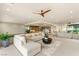 Bright and airy living room showcasing an open-concept layout with a sectional sofa and modern ceiling fan at 11152 San Terrazo Pl, Las Vegas, NV 89141
