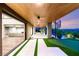 Covered outdoor patio featuring a putting green, seating area, and views of the surrounding landscape at 11152 San Terrazo Pl, Las Vegas, NV 89141