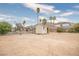 Large backyard with a storage shed, surrounded by palm trees and mountain views at 138 Palma Del Rio, Las Vegas, NV 89110