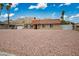 Single-story home with desert landscaping, an attached garage and views of the nearby mountain at 138 Palma Del Rio, Las Vegas, NV 89110