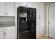 Spacious kitchen with modern black refrigerator and abundant white cabinet storage at 138 Palma Del Rio, Las Vegas, NV 89110