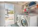 Laundry room with washer, dryer, open shelving and exterior access to the backyard at 138 Palma Del Rio, Las Vegas, NV 89110