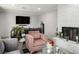 The living room features a sofa, arm chairs, large windows, a fireplace and a TV on the wall at 138 Palma Del Rio, Las Vegas, NV 89110