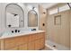 Stylish bathroom with double vanity, arched mirrors, and walk-in shower at 1705 Imperial Cup Dr, Las Vegas, NV 89117
