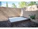 Enclosed backyard with wood-framed sandbox and stone landscaping at 2198 Maderno St, Henderson, NV 89044