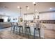 Open-concept kitchen featuring granite countertops, stainless steel appliances, island with seating, and modern pendant lighting at 2198 Maderno St, Henderson, NV 89044